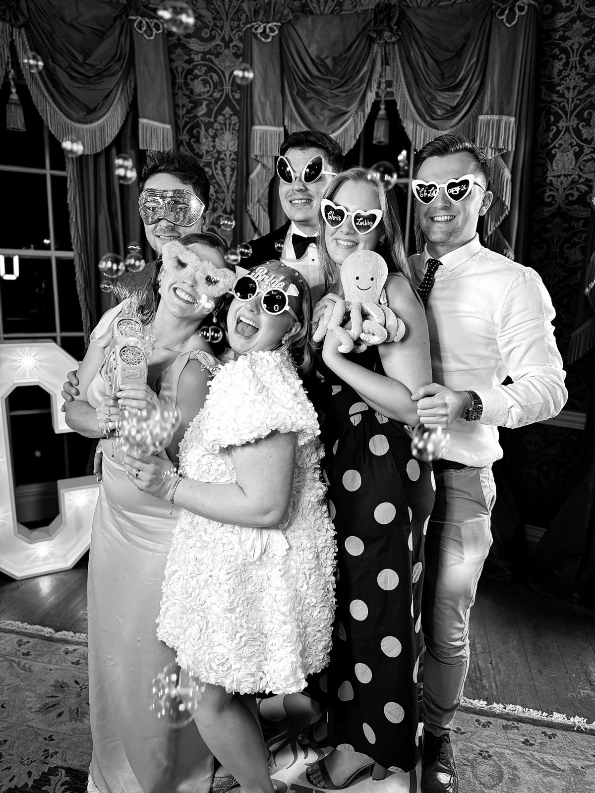 Wedding guests with a black and white printed keepsake from a hosted photo booth